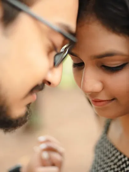 An intimate close-up of the couple with their foreheads together. This tight framing emphasizes their closeness and the quiet, peaceful moment they are sharing.