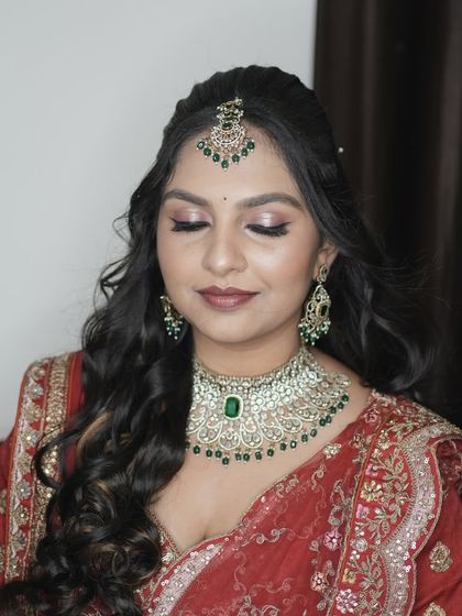 A close-up of Amrutha's reception makeup. This shot highlights the flawless base, shimmery eye makeup, and perfectly coordinated jewelry.