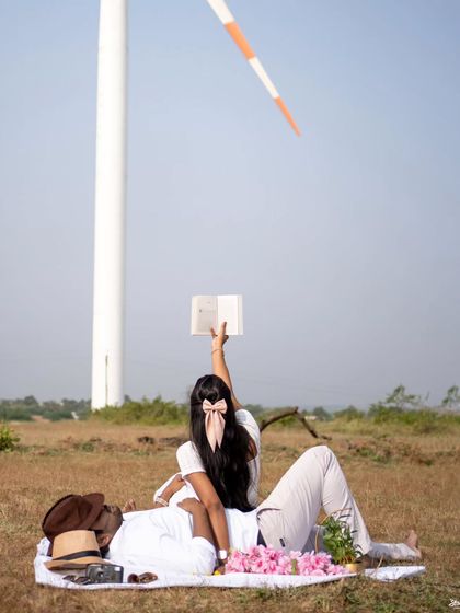 A creative pre-wedding shot with a book and a windmill, telling a story of shared dreams and relaxation.