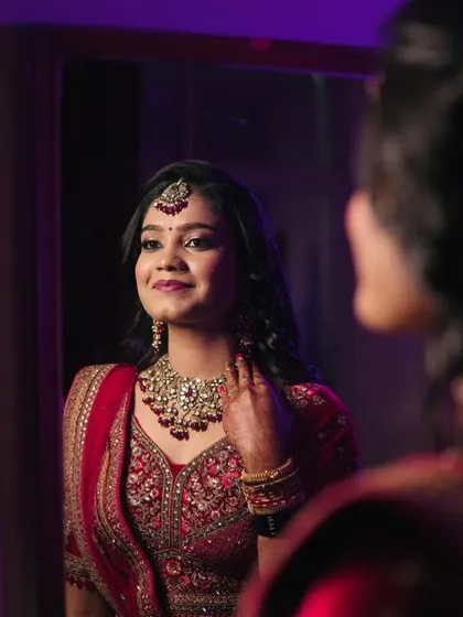 A moment of reflection. The bride looks into the mirror, and her beautiful jewellery set catches the light perfectly, showcasing its brilliance.