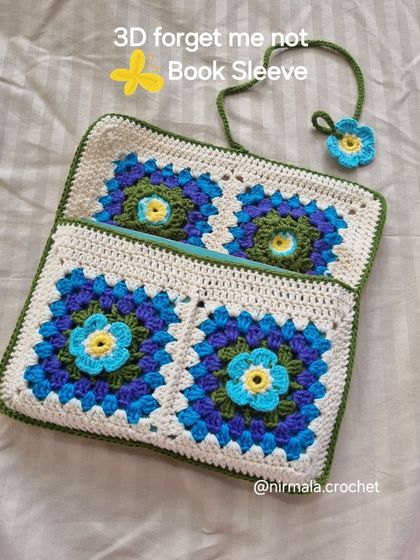 This book sleeve features 3D "forget-me-not" flowers, adding beautiful texture and dimension to the design. It also includes a matching floral bookmark.