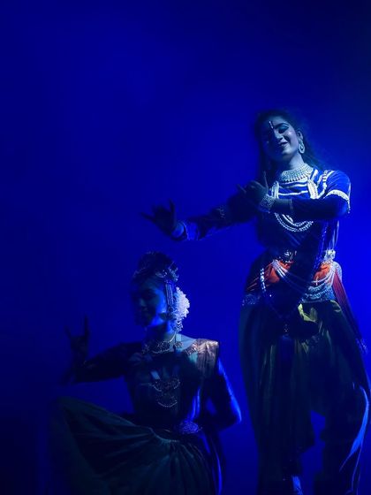 A beautifully lit moment from "KRISHNA", where the deep blue background makes the dancers' expressions and movements stand out with clarity and grace.