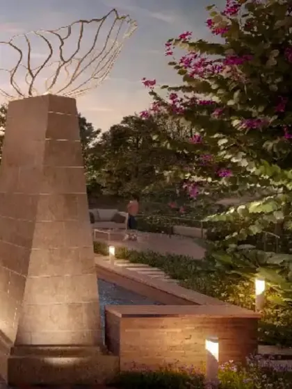 Happy Diwali from Green Space Alliance. The warm uplighting on this sculptural pillar and surrounding foliage creates a serene and celebratory atmosphere in this landscape design.
