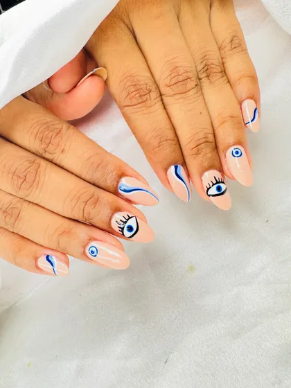 Keep the bad vibes away with this trendy evil eye nail art. I hand-paint each design on a clean nude base, combining detailed eye art with modern abstract blue swirls for a unique, protective style.