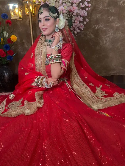 Another angle of the gorgeous red bridal lehenga, highlighting the gold border on the dupatta and the rich color that is perfect for any traditional ceremony.