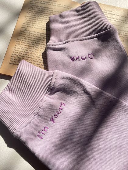 Simple, sweet, and personal. These matching lavender sweatshirts have little messages, 'I'm yours' and 'Khu', embroidered on the cuffs.