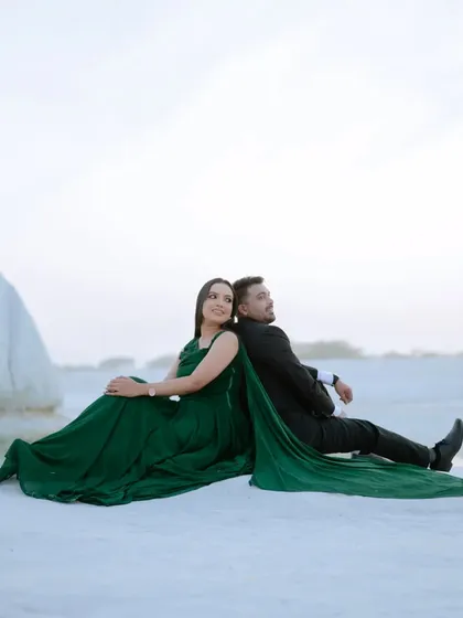 A relaxed, back-to-back pose by the water. This casual and intimate moment provides a lovely contrast to the more formal, posed shots in a pre-wedding album.