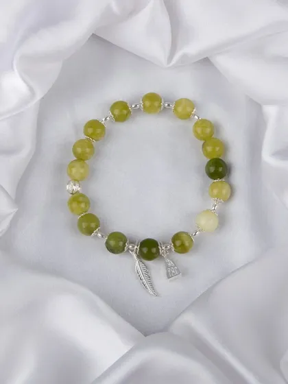 A green beaded bracelet with silver feather and initial charms.