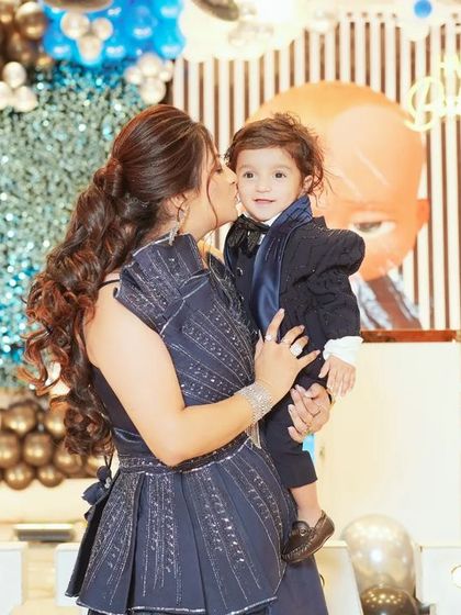 A mother's love captured in a single frame. This sweet, unposed photo shows a mother giving her son a kiss during his birthday celebration, a memory to cherish forever.