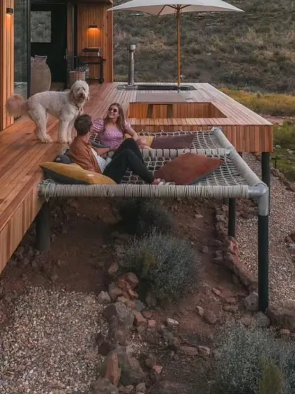 We design spaces for relaxation and connection. This custom deck features an integrated hammock net, offering a unique and comfortable spot to enjoy the outdoors with family and pets.