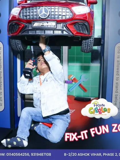 Welcome to the Fix-It Fun Zone! Here, kids can pretend to be mechanics, using toy tools to work on a kid-sized car lift. It's a unique role-playing area that sparks creativity.