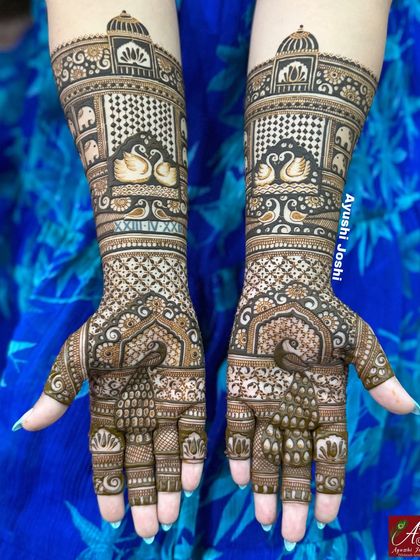 A beautiful Indian mehendi design for the groom's bhabhi, featuring peacocks, swans, and mini elephants.