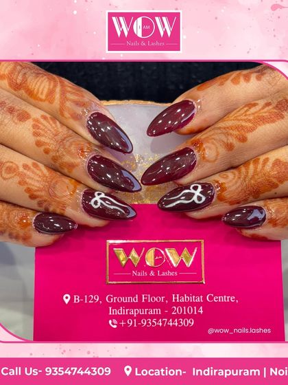 A beautiful design for a festive occasion. These almond-shaped nails feature a deep burgundy base with intricate white line art, perfectly complementing the henna.
