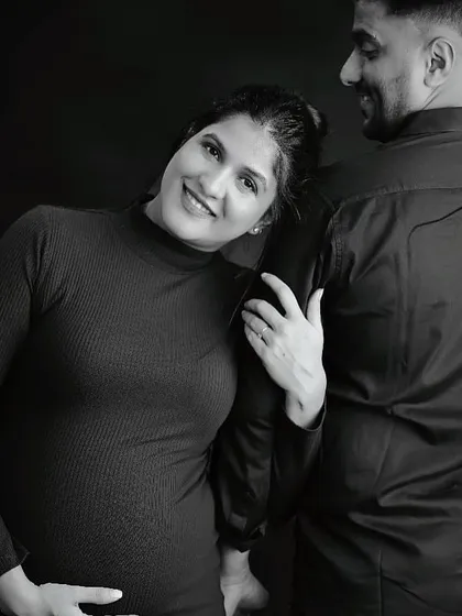 A sweet and candid black and white maternity shot capturing a genuine smile.