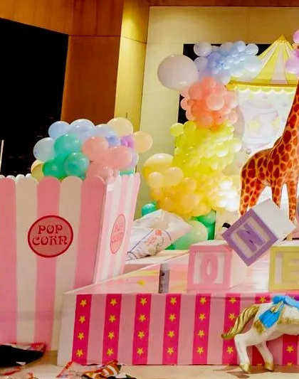 A close up of carnival props, including a giant popcorn box and a carousel horse.