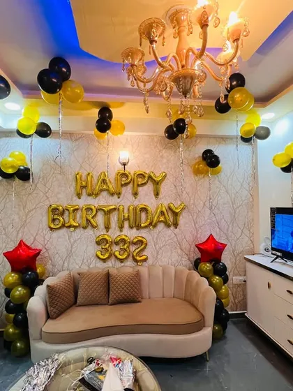 A simple yet festive living room decoration using foil 'Happy Birthday' letters, balloon pillars, and ceiling balloons.