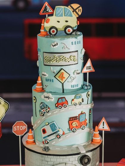 A detailed shot of the 'Road Attack' birthday cake, complete with edible road signs, cars, and a construction site motif.