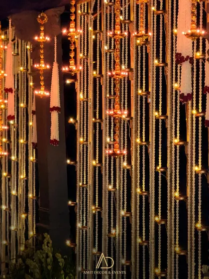 The hanging diya curtains illuminated at night, creating a warm, magical glow that fills the entire space with divine energy.