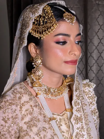 Creating this soft and regal Nikkah look for Afrin was a dream. The makeup features subtle pink tones on the eyes and lips to complement her ivory and gold outfit, letting her Nizami jewellery, including the elegant passa, take center stage.