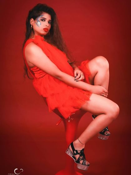 A powerful seated pose on a red stool. The composition is strong, and her expression is full of attitude.