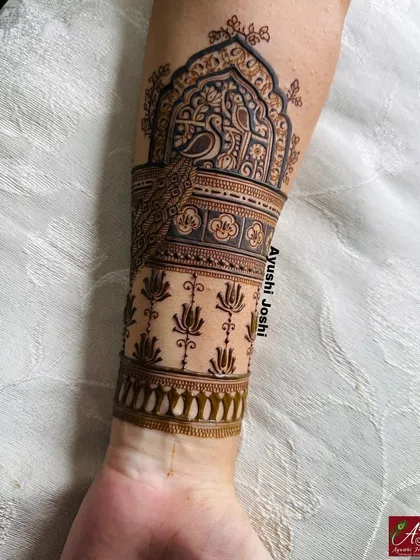 A close-up of the armband from the baby shower mehendi, featuring a graceful peacock and lotus motifs.
