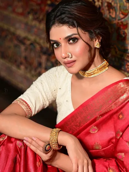 A close-up of Sauraseni from the same shoot, focusing on her elegant jewellery and makeup. The gold choker and subtle nose ring perfectly accessorize the traditional look.