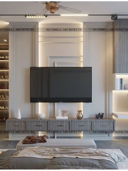 The TV wall in this bedroom is a study in functional elegance. It incorporates a floating media console, an integrated study desk with shelving, and a walk-in closet concealed behind a matching door.