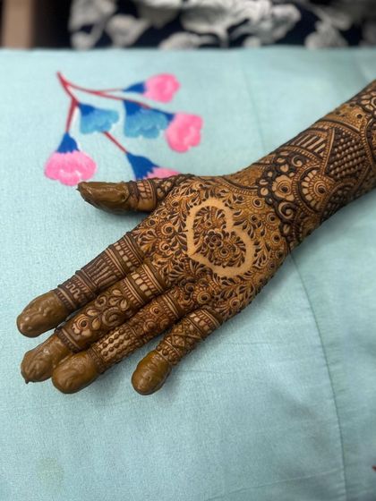 A simple yet beautiful heart motif left as negative space on the back of the hand. This is a popular request for brides who want a touch of romance in their design.