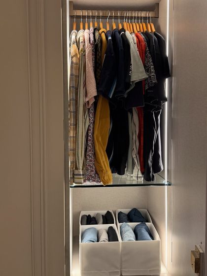 Even a narrow closet can be highly functional. We used hanging space for shirts and jackets, with bins below for folded clothes and shoes.