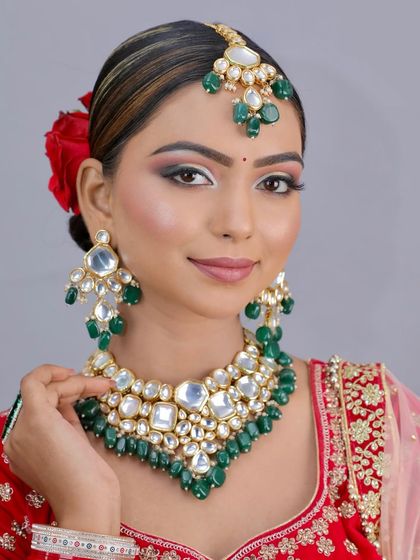 Another beautiful bridal look created by a student, featuring a green and red color scheme. They learn to work with contrasting colors effectively.