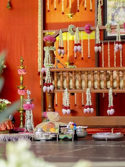 A close-up of the decorated cradle and religious idols for a traditional Hindu naming ceremony.