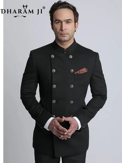 A model wearing a sharp, black double-breasted Jodhpuri suit. This is a powerful and modern take on a traditional silhouette.