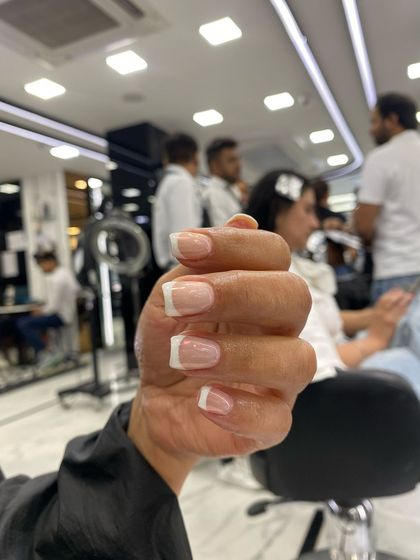 A classic square-shaped French manicure. The clean lines and natural pink base create a timeless and sophisticated look that is always in style.