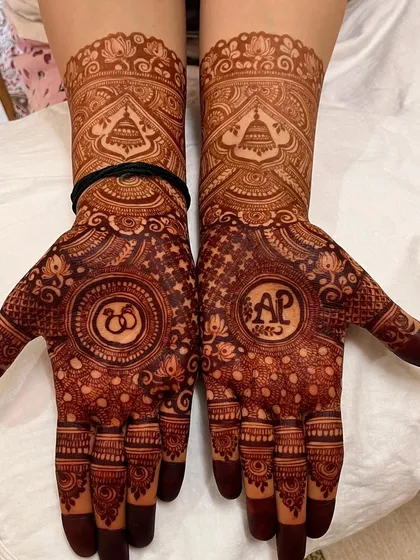 A close-up of the deep maroon stain on the personalized 'AP' engagement mehendi.