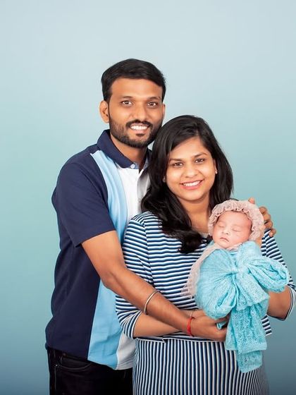 The first family photo. This studio portrait captures the new family of three, smiling and happy, marking the beginning of their journey together.