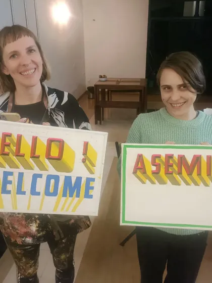 A closer look at the happy clients with their custom-painted signs.