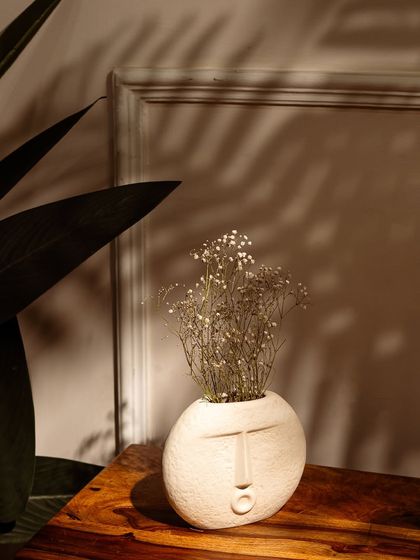 The round version of the face vase, also styled with delicate dried flowers and beautiful, natural lighting.