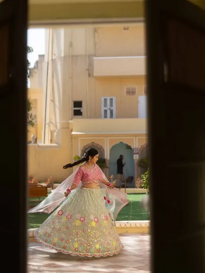 A candid shot of the bride twirling, framed by a doorway. We work with photographers to capture these moments of spontaneous joy.