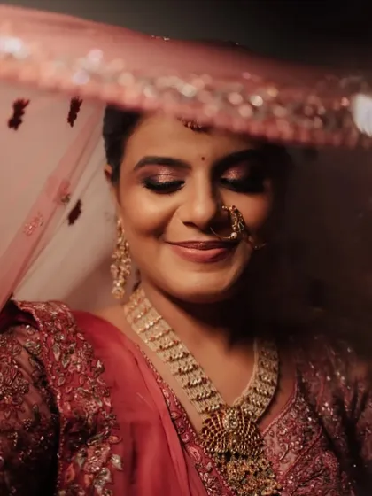 A dreamy shot of the bride under her veil. The soft focus highlights her glowing smile and the subtle shimmer on her eyelids, creating a truly magical moment.