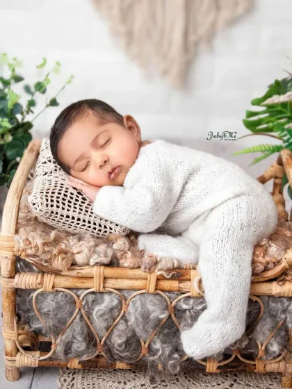 I love the simplicity of this shot, with the baby in a white outfit on a natural-textured bed. It creates a timeless and earthy feel for his first photoshoot.