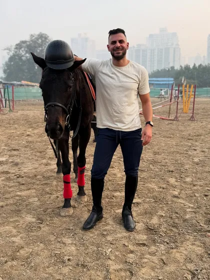A full-body shot of a client posing with his horse in our sand arena. The open space allows for a variety of portrait styles, from close-ups to wider environmental shots.
