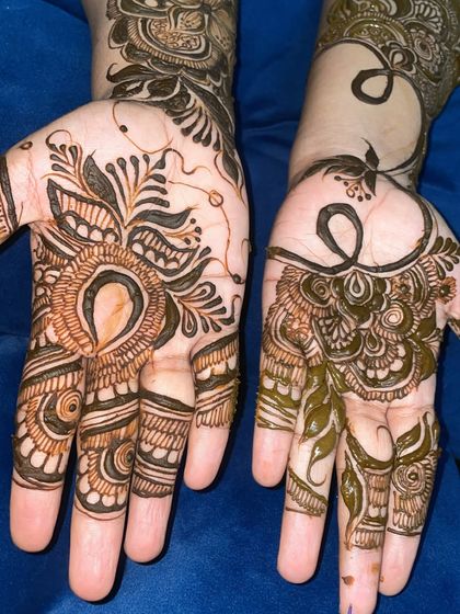 A unique two-part design, with one hand featuring a bold Arabic floral motif and the other a flowing vine.