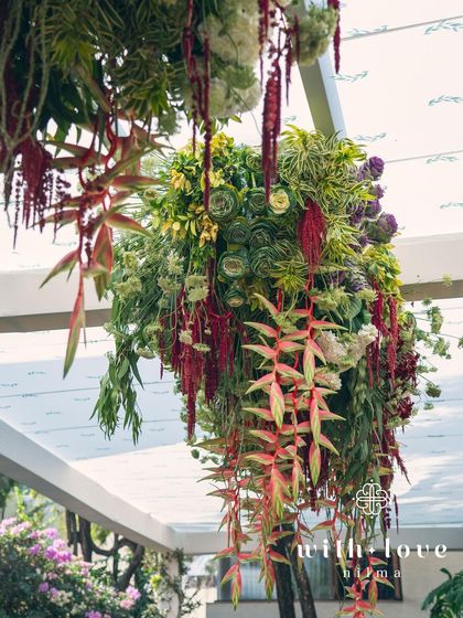 A hanging floral installation from the 'Garden of Gaia' event, featuring a mix of tropical flowers and greenery.