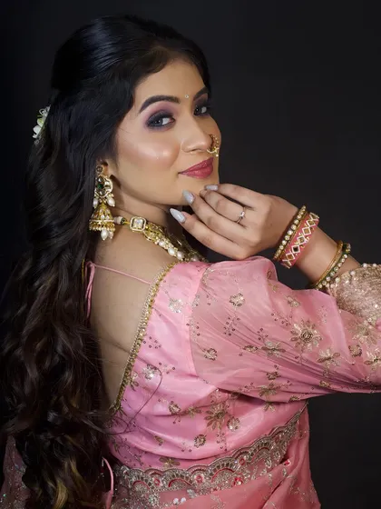 A beautiful portrait of a model in a soft pink saree, showcasing a modern party makeup look with a focus on elegant jewellery.