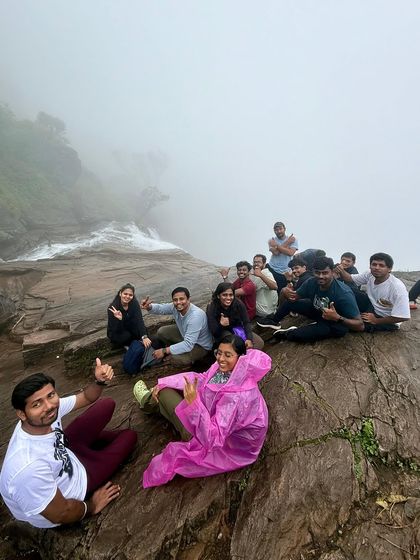 Relaxing on the rocks near the falls. These are the moments of rest and friendship that make our group treks so special.