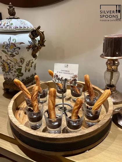 Another shot of the elegant Churros and Hot Chocolate setup, this time with a beautiful porcelain urn in the background, showcasing how my food presentation complements the event decor.