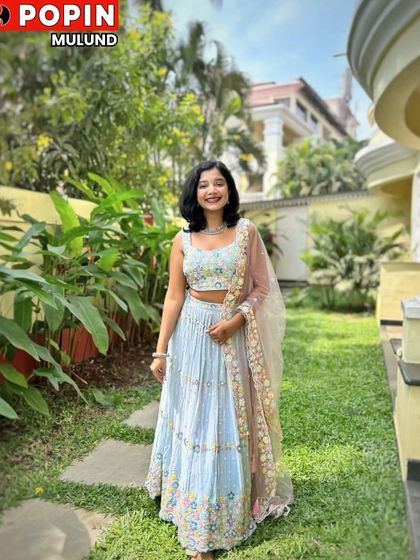 A lovely portrait of the client in the garden, showcasing the delicate floral embroidery on her lehenga.
