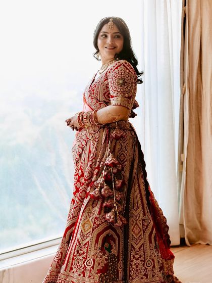 A beautiful shot of Shikha by the window. The natural light catches the soft glow of her makeup, highlighting the fresh and radiant skin finish we created.