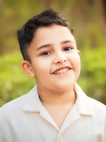 A simple, close-up child portrait that lets his personality shine through. The soft, natural light highlights his warm smile and bright eyes.