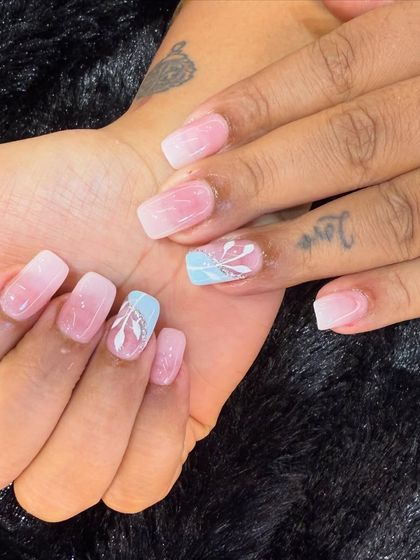 A soft and pretty design with a touch of blue. This set features a baby boomer ombre on a short, square nail, with delicate hand-painted white foliage on a blue accent nail.